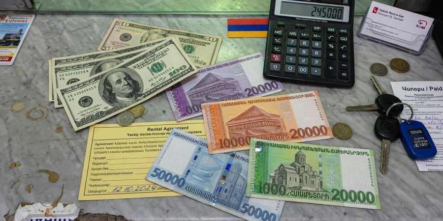 US dollar bills and Armenian dram banknotes on a rental counter in Yerevan