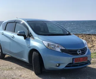 Frontvisning av en leiebil Nissan Note i Pafos, Kypros ✓ Bil #1215. ✓ Automatisk TM ✓ 0 anmeldelser.