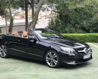 Sprednji pogled najetega avtomobila Mercedes-Benz E200 Cabrio v v kraju Rafailovici, Črna gora ✓ Avtomobil #2021. ✓ Menjalnik Samodejno TM ✓ Mnenja 5.