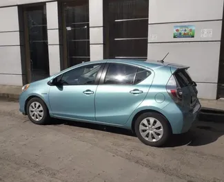 Sprednji pogled najetega avtomobila Toyota Prius C v v Kutaisiju, Georgia ✓ Avtomobil #2067. ✓ Menjalnik Samodejno TM ✓ Mnenja 1.