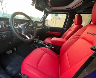 Interior do Jeep Wrangler Sahara para aluguer nos Emirados Árabes Unidos. Um excelente carro de 5 lugares com transmissão Automático.