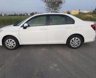 Predný pohľad na prenajaté auto Toyota Corolla Axio v v Larnake, Cyprus ✓ Auto č. 6514. ✓ Prevodovka Automatické TM ✓ Hodnotenia 0.