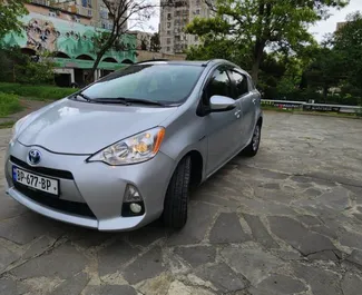 Sprednji pogled najetega avtomobila Toyota Prius C v v Tbilisiju, Georgia ✓ Avtomobil #6484. ✓ Menjalnik Samodejno TM ✓ Mnenja 1.