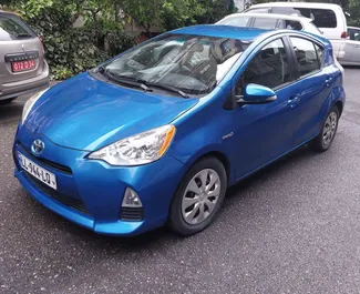 Sprednji pogled najetega avtomobila Toyota Prius C v v Tbilisiju, Georgia ✓ Avtomobil #6572. ✓ Menjalnik Samodejno TM ✓ Mnenja 3.