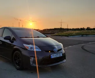 Sprednji pogled najetega avtomobila Toyota Prius v v Tbilisiju, Georgia ✓ Avtomobil #6600. ✓ Menjalnik Samodejno TM ✓ Mnenja 0.