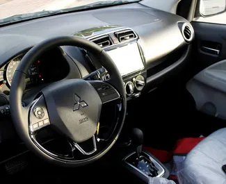Interior de Mitsubishi Attrage para alquilar en los EAU. Un gran coche de 5 plazas con transmisión Automático.