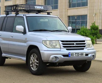 Vista frontal de un Mitsubishi Pajero Io de alquiler en Tiflis, Georgia ✓ Coche n.º 6690. ✓ Automático TM ✓ 0 opiniones.