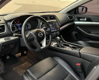 Interior de Nissan Maxima para alquilar en los EAU. Un gran coche de 5 plazas con transmisión Automático.