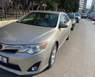 Vista frontal de um aluguel Toyota Camry em Tbilisi, Geórgia ✓ Carro #8028. ✓ Transmissão Automático TM ✓ 0 avaliações.