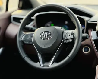 Toyota Corolla Cross 2023 tilgængelig til leje i Dubai, med 250 km/dag kilometertæller grænse.