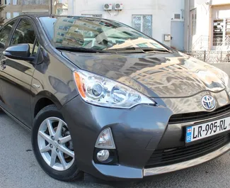 Sprednji pogled najetega avtomobila Toyota Prius C v v Tbilisiju, Georgia ✓ Avtomobil #9241. ✓ Menjalnik Samodejno TM ✓ Mnenja 0.