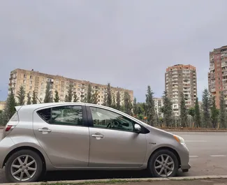 Vista frontal de un Toyota Prius C de alquiler en Tiflis, Georgia ✓ Coche n.º 9185. ✓ Automático TM ✓ 0 opiniones.