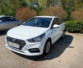 Sprednji pogled najetega avtomobila Hyundai Solaris v v Kaliningradu, Rusija ✓ Avtomobil #9004. ✓ Menjalnik Samodejno TM ✓ Mnenja 0.