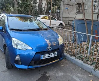 Sprednji pogled najetega avtomobila Toyota Prius C v v Tbilisiju, Georgia ✓ Avtomobil #9240. ✓ Menjalnik Samodejno TM ✓ Mnenja 1.