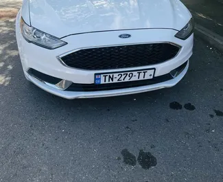 Vista frontal de un Ford Fusion Sedan de alquiler en Tiflis, Georgia ✓ Coche n.º 9726. ✓ Automático TM ✓ 0 opiniones.