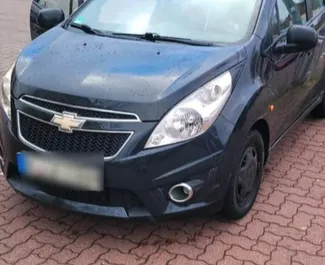 Vista frontal de um aluguel Chevrolet Spark no aeroporto de Tirana, Albânia ✓ Carro #10012. ✓ Transmissão Manual TM ✓ 0 avaliações.