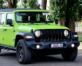 Vista frontal de un Jeep Wrangler Sahara de alquiler en Tiflis, Georgia ✓ Coche n.º 10144. ✓ Automático TM ✓ 0 opiniones.