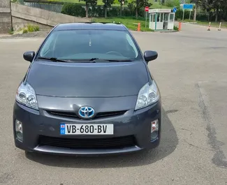 Vista frontal de um aluguel Toyota Prius em Tbilisi, Geórgia ✓ Carro #10237. ✓ Transmissão Automático TM ✓ 0 avaliações.