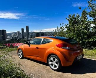 Vista frontal de un Hyundai Veloster de alquiler en Kutaisi, Georgia ✓ Coche n.º 10800. ✓ Automático TM ✓ 0 opiniones.