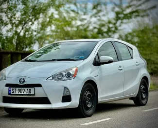 Sprednji pogled najetega avtomobila Toyota Prius C v v Kutaisiju, Georgia ✓ Avtomobil #8654. ✓ Menjalnik Samodejno TM ✓ Mnenja 0.