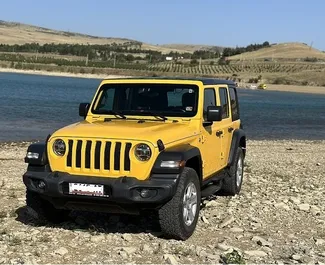 Frontvisning av en leiebil Jeep Wrangler i Tbilisi, Georgia ✓ Bil #10830. ✓ Automatisk TM ✓ 0 anmeldelser.