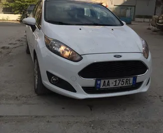 Vista frontal de um aluguel Ford Fiesta no aeroporto de Tirana, Albânia ✓ Carro #11487. ✓ Transmissão Manual TM ✓ 0 avaliações.