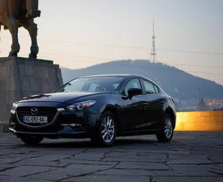 Vista frontal de um aluguel Mazda 3 em Tbilisi, Geórgia ✓ Carro #10158. ✓ Transmissão Automático TM ✓ 0 avaliações.