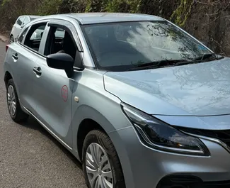 Front view of a rental Suzuki Baleno at Goa Airport, Goa ✓ Car #16196. ✓ Manual TM ✓ 0 reviews.