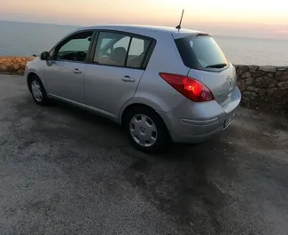 Vista frontal de un Nissan Versa de alquiler en el aeropuerto de Podgorica, Montenegro ✓ Coche n.º 16482. ✓ Automático TM ✓ 0 opiniones.