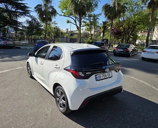 Toyota Yaris 2023 automašīnas noma Gruzijā, iezīmes ✓ Hibrīds degviela un 115 zirgspēki ➤ Sākot no 110 GEL dienā.